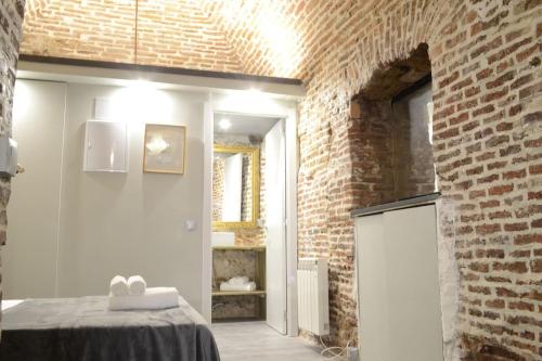 a room with a table and a brick wall at Cozy Loft - Royal Palace in Madrid