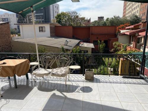 - un balcon avec une table et des chaises dans l'établissement HABITACIONES PRIVADAS NOVILLO, à Cochabamba