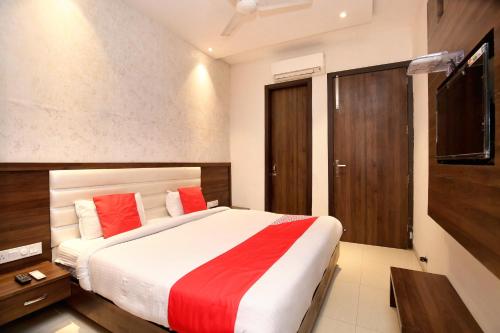 a bedroom with a large bed with red pillows at Hotel Winner Inn in Amritsar