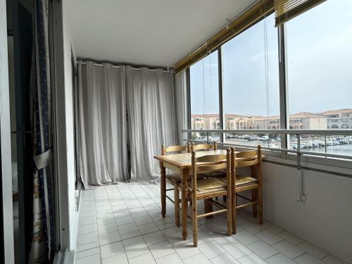 un balcon avec une table et des chaises et une grande fenêtre dans l'établissement Confortable 2 pièces cabine à Sète, proche plage et commerces - FR-1-338-516, à Sète