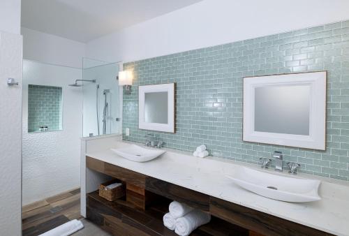 a bathroom with two sinks and a mirror at The Ambergris Grand in San Pedro