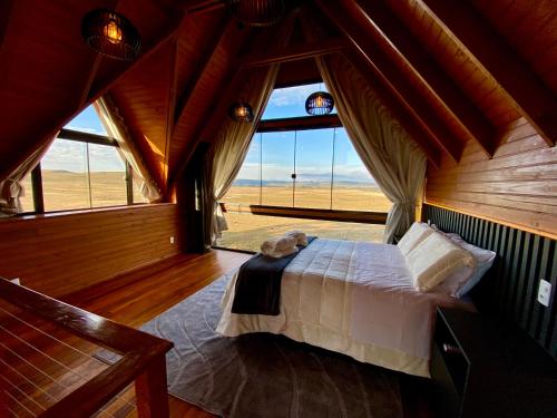 um quarto com uma cama num quarto com uma janela em Cabanas Arroio Da Serra em Cambará