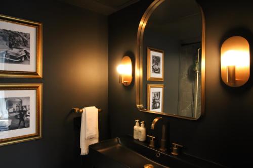 a bathroom with a sink and a mirror at MrNomad Boutique Hotel Parisian Townhouse in Dallas
