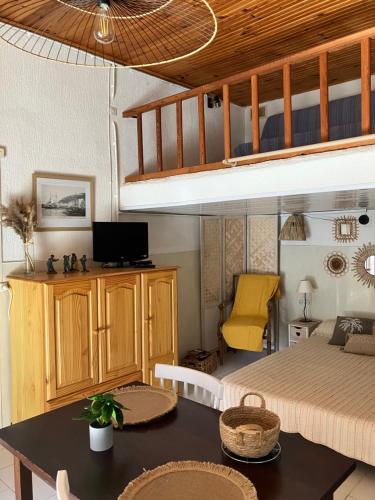 Sala de estar con cama y mesa de comedor en Studio Olmeto, en Olmeto