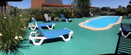 a swimming pool with two lounge chairs and a swimming pool at Brisas del Ceferino in Sierra de la Ventana