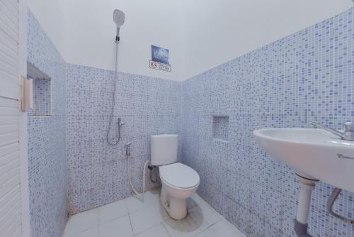 a bathroom with a toilet and a sink at Reddoorz near Juwata Airport Tarakan in Tarakan