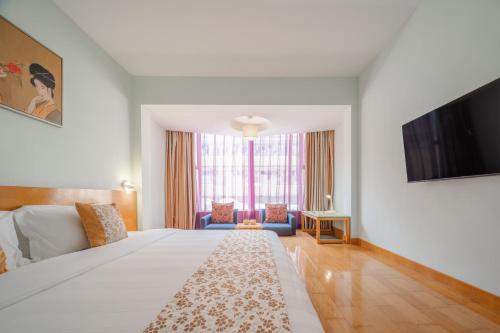 a living room with a bed and a tv at Shanshui Trends Hotel - Huaqiangbei in Shenzhen