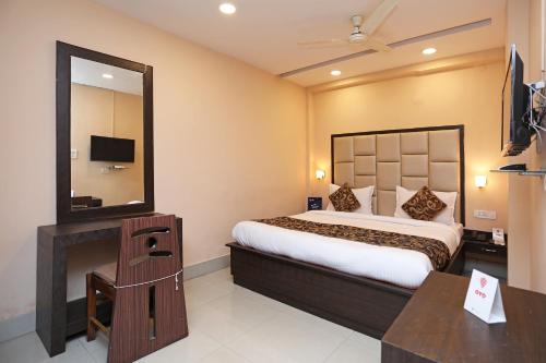 Pokój hotelowy z łóżkiem i lustrem w obiekcie Collection O Hotel Greenpark w mieście Jamshedpur