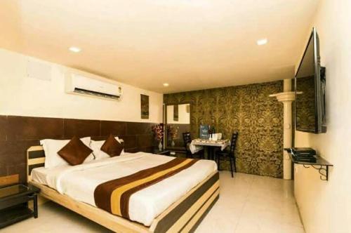 a bedroom with a large bed and a desk in it at Collection O Church View Near St. Thomas's Church in Kolkata