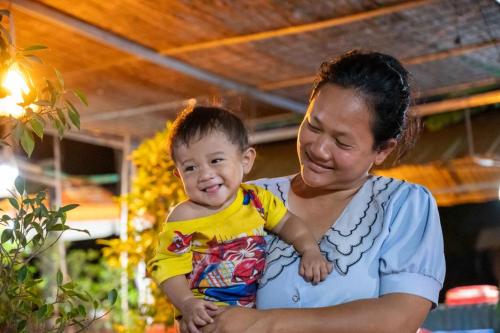 a woman holding a baby in her arms at Phonluer Angkor Homestay, in Siem Reap