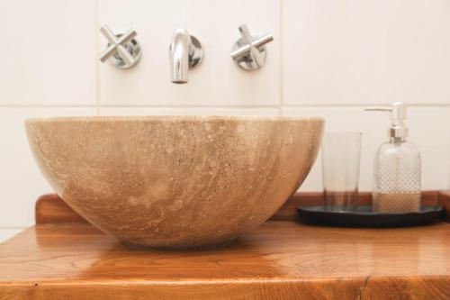 a bowl on a wooden table with a sink at Bories - Boutique Guest House in Puerto Natales