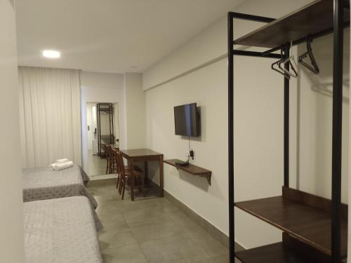 Schlafzimmer mit einem Bett, einem Schreibtisch und einem TV in der Unterkunft ILUSION FLAT-Ponta Negra in Natal