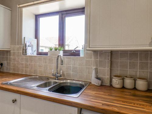 a kitchen counter with a sink and a window at Farrow in Scarborough