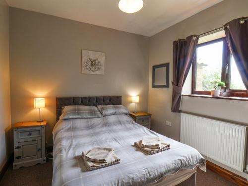 a bedroom with a large bed with two tables and two windows at Farrow in Scarborough