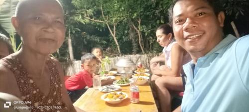 a group of people sitting at a table with food at Phonluer Angkor Homestay, in Siem Reap