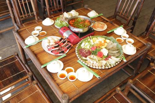 a wooden table with plates of food on it at KHU DU LỊCH SINH THÁI HÒN MÁT in Vĩnh Yên