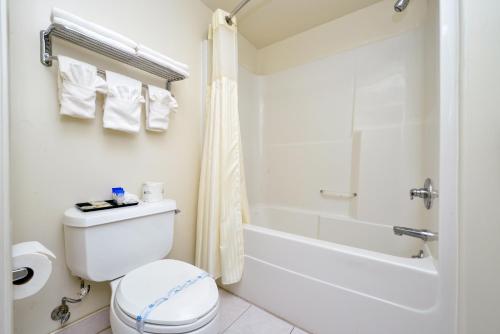 a bathroom with a toilet and a tub and a shower at Americas Best Value Inn - Sky Ranch Palo Alto in Palo Alto