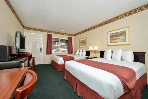 a hotel room with two beds and a flat screen tv at Americas Best Value Inn - Sky Ranch Palo Alto in Palo Alto