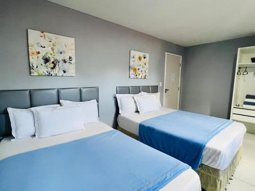 duas camas num quarto com azul e branco em Edifício Creta em São Luís