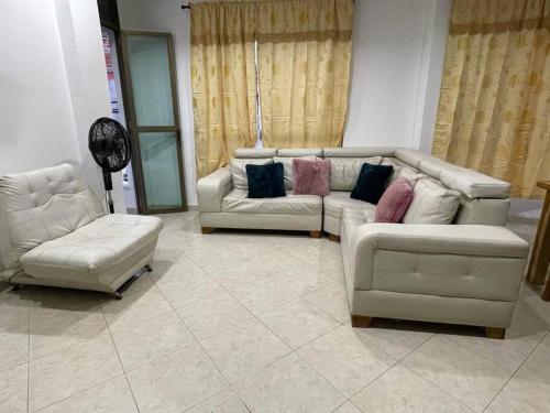 una sala de estar con 2 sofás blancos y sillas en Para buenos gustos, buen confort, en Tumba