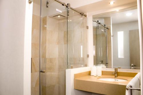 a bathroom with a sink and a glass shower at La Casa del Reloj - Zona de Hospitales in Mexico City