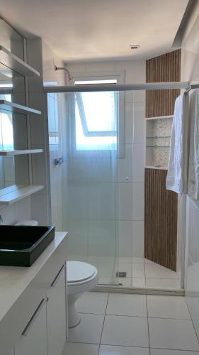 y baño con ducha de cristal y aseo. en Apartamento-Cobertura de Luxo Vista Mar em Salvador en Salvador