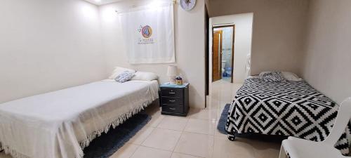 um quarto com duas camas e uma janela. em "La #4 Mi Casa es tu Casa"Apt #1 Giron, Azuay,Ecuador 