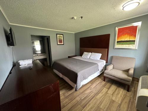 une chambre d'hôtel avec un lit et une chaise dans l'établissement Studio Suites, à San Antonio