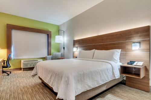 a hotel room with a large bed and a window at Holiday Inn Express Hotel & Suites Lake Elsinore by IHG in Lake Elsinore