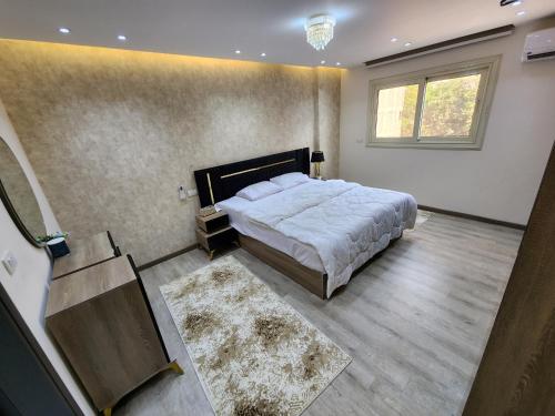 a bedroom with a large bed and a window at شقة راقية فندقية فرش جديد عمارة فندقيه المهندسين الجيزة in Cairo