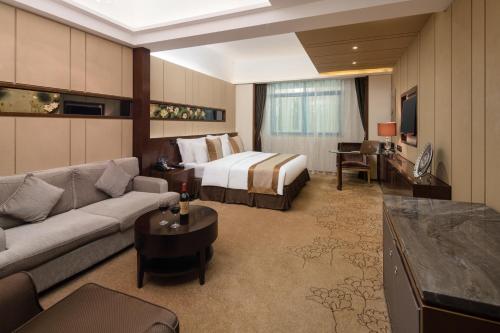 MaomingにあるMaoming International Hotelのベッドとソファ付きのホテルルーム