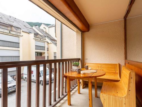 d'un balcon avec une table en bois, une table et des chaises. dans l'établissement Studio Saint-Lary-Soulan, 1 pièce, 4 personnes - FR-1-296-473, à Saint-Lary-Soulan