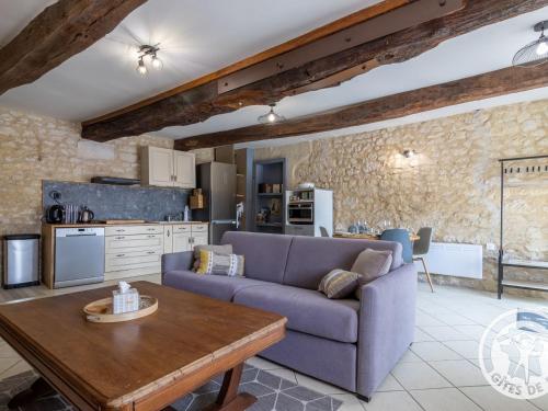 un salon avec un canapé et une table dans l'établissement Gîte charmant en tuffeau près de Saumur avec terrasse, poêle à bois et grandes commodités - FR-1-622-64, à Vaudelnay