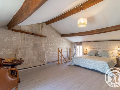 1 dormitorio con cama y pared de piedra en Gîte Vaudelnay, 2 pièces, 2 personnes - FR-1-622-64, en Vaudelnay