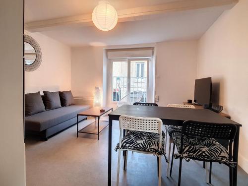 un salon avec une table, des chaises et un canapé dans l'établissement T2 cosy à 30m de la plage avec wifi au centre ville - FR-1-746-13, à Luc-sur-Mer