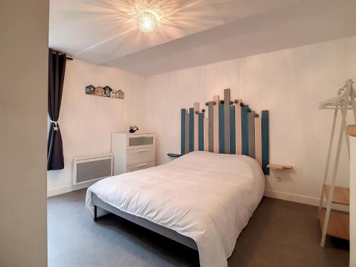 - une chambre avec un lit blanc et un plafond dans l'établissement T2 cosy à 30m de la plage avec wifi au centre ville - FR-1-746-13, à Luc-sur-Mer