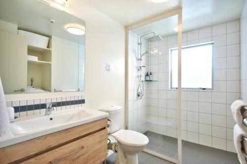 Un baño blanco con lavabo e inodoro. en The Whistler Holiday Apartments, en Queenstown