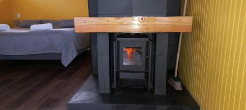 a fireplace in a room with a bed at Cabañas Quimantu-Aguas Calientes in Puerto Varas