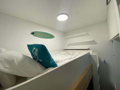 Habitación pequeña con cama y cartel en la pared en Departamento de playa - Condominio Ocean Reef - San Bartolo, en San Bartolo