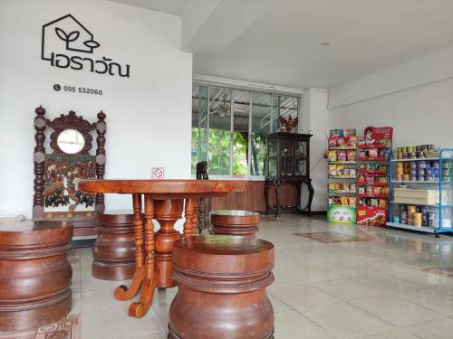 una habitación con una mesa y taburetes en una tienda en ERAWAN PLACE, en Mae Sot