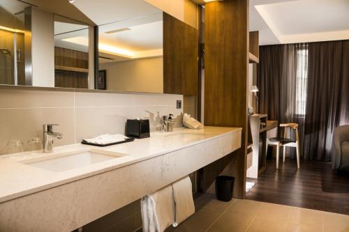 un bagno con due lavandini e un grande specchio di Just Sleep Kaohsiung Zhongzheng a Kaohsiung