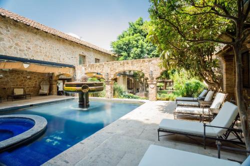 una piscina al aire libre con una fuente en un patio en Quinta Real Guadalajara, en Guadalajara