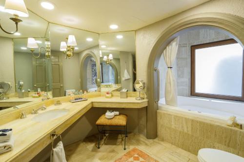 La salle de bains est pourvue d'une grande baignoire, d'un lavabo et d'une baignoire. dans l'établissement Quinta Real Guadalajara, à Guadalajara