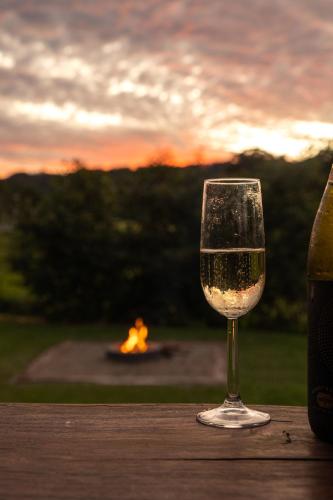 a glass of wine sitting on a table with a baseball game at Blackwattle Farm in Beerwah