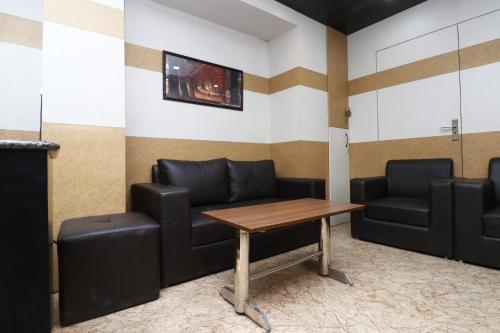 a waiting room with leather couches and a table at Hotel Abc Residency in Jawāharnagar