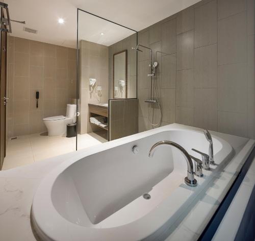 uma casa de banho branca com um lavatório e um WC em Le Palmier Ho Tram Resort em Ho Tram