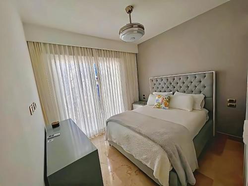 Un dormitorio con una cama grande y una ventana en Penthouse Chic en Cana Rock Condos #23, en Punta Cana