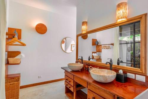 a bathroom with two sinks and a large mirror at Casa la Onda in Santa Teresa Beach