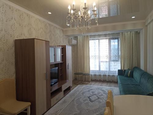 ein Wohnzimmer mit einem Sofa und einem TV in der Unterkunft Orion Apartment in Bischkek