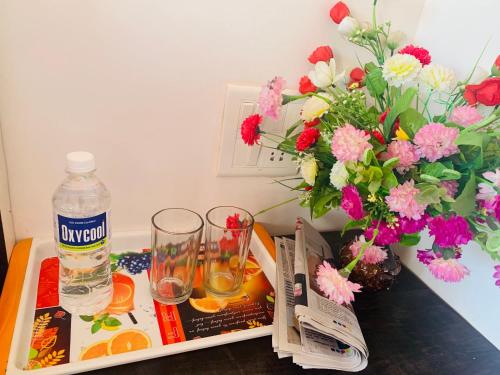 una mesa con una botella de agua y una revista y flores en Stay Classy, en Mahabaleshwar